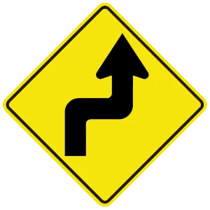Road sign: The road ahead turns sharply right, then sharply left.