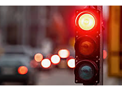 A driver approaching a flashing red traffic signal must: